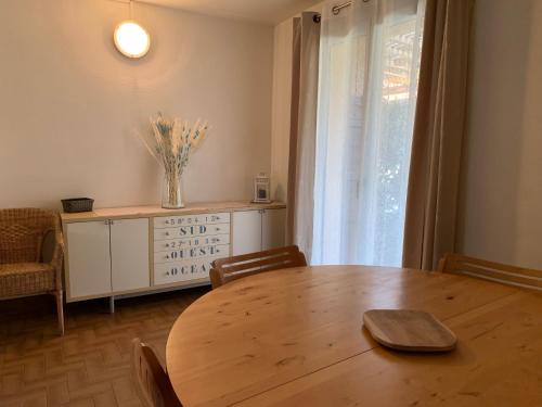 a dining room with a wooden table and a window at LOGIS HOTELS - Hôtel et Restaurant L'Océana in Lanton