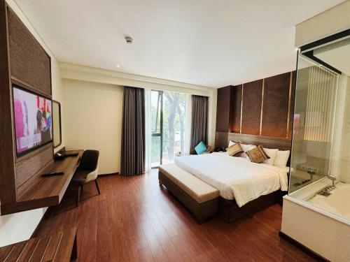 a hotel room with a bed and a television at Northern Charm Hotel in Ho Chi Minh City