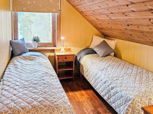 Duas camas num quarto com uma janela em Holiday home Bygstad em Bygstad
