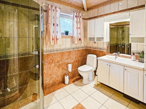 ein Bad mit einem WC, einem Waschbecken und einer Dusche in der Unterkunft Holiday home Bygstad in Bygstad