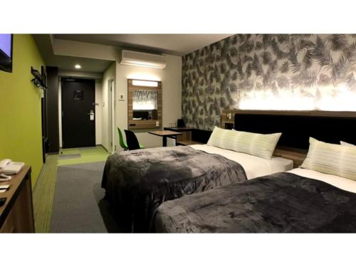 a hotel room with two beds and a desk at Green Rich Hotel Okinawa Nago - Vacation STAY 49918v in Nago
