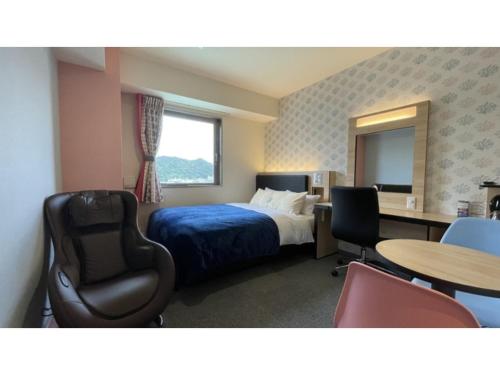 名護市にあるGreen Rich Hotel Okinawa Nago - Vacation STAY 55394vのベッド、デスク、椅子が備わるホテルルームです。