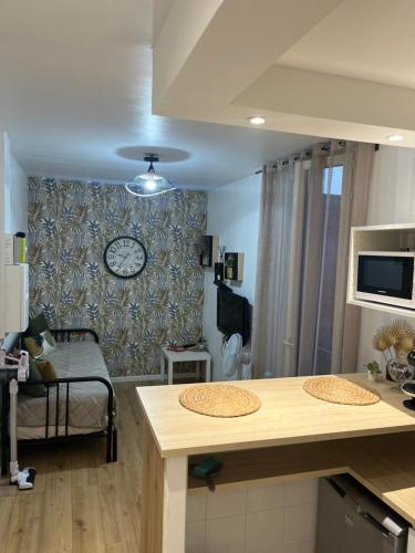 a kitchen and living room with a clock on the wall at Cosy Appartement Nid de rêve in Aubervilliers