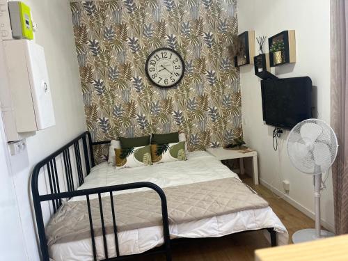 um quarto com uma cama com um relógio na parede em Appartement confortable Olympic games JO24 em Aubervilliers