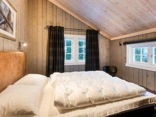 a large bed in a room with wooden walls at 10 person holiday home in Fåvang in Strande