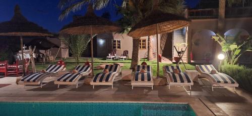 a group of chairs and umbrellas next to a pool at Jenny Lynn in Marrakech
