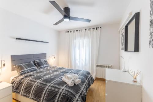 a bedroom with a bed and a ceiling fan at Moratalaz in Madrid
