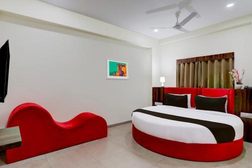 a bedroom with a red bed and a red couch at OYO Hotel HILL PARK I in Vadodara