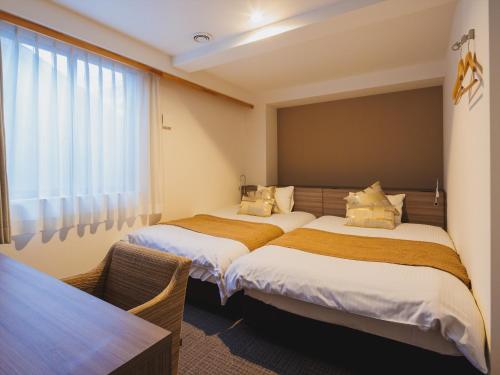 a bedroom with two beds and a window at Giappo Franca Kyoto in Kyoto