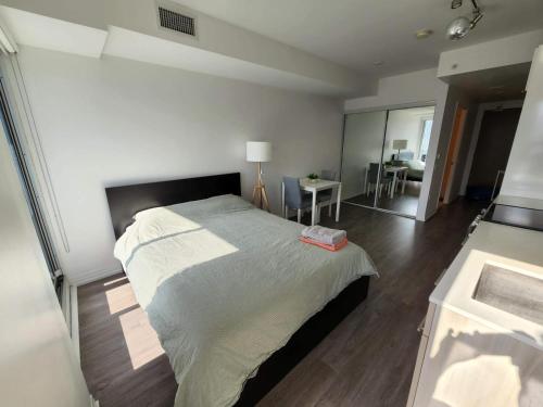 多倫多的住宿－Toronto Premier INN，一间卧室配有一张大床和一张桌子