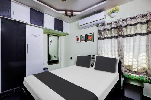 1 dormitorio con cama blanca y ventana en OYO SS Home Stay - An Unique Home Stay, en Tirupati