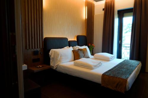 a hotel room with a bed with pillows and a window at Albergo Ristorante Papa in Peschiera del Garda