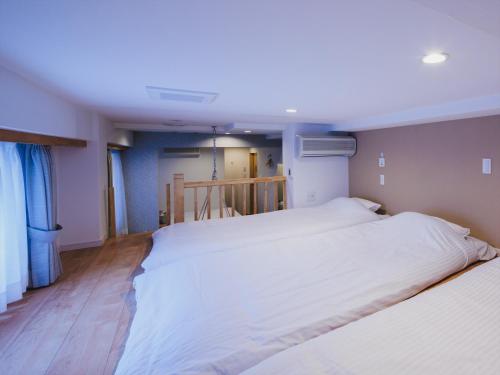 a bedroom with two white beds in it at Giappo Franca Kyoto in Kyoto