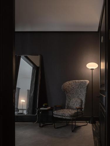 a room with a chair and a mirror and a lamp at Opartment - People's Square 远东饭店 - 人民广场 in Shanghai