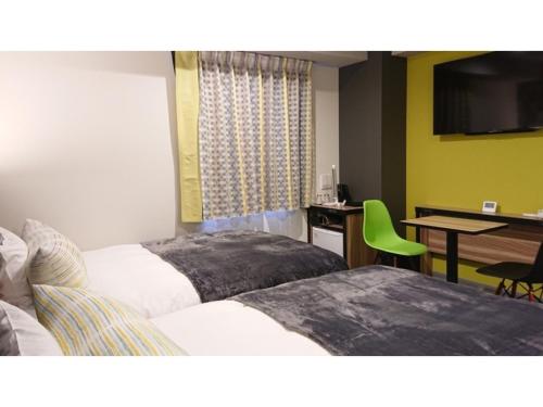 名護的住宿－Green Rich Hotel Okinawa Nago - Vacation STAY 49920v，酒店客房设有两张床和一张桌子。