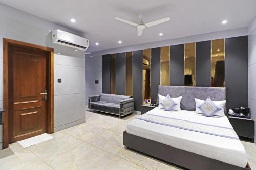a bedroom with a bed and a chair and a door at Frankstay By Hotel Preet in 05 mints walking Distance Nizamuddin Railway Station in New Delhi