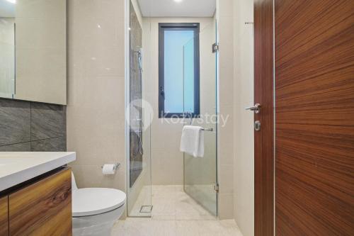 a bathroom with a toilet and a glass shower at Avalon by Kozystay - BSD in Tangerang