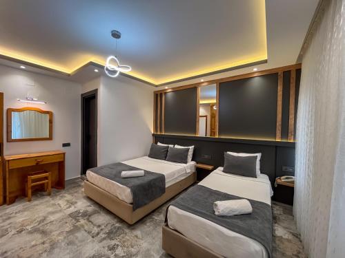 a hotel room with two beds and a desk at Rain Hotel in Kizkalesi
