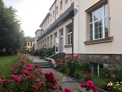 a building with pink flowers in front of it at Grandhotel Nový Bor in Nový Bor