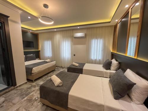 a hotel room with two beds and a television at Rain Hotel in Kizkalesi