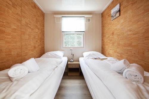 two beds in a small room with a window at 85, Private, Parking - Nature - Central - AC - Serene! in Oisterwijk