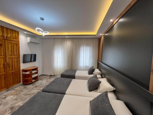 a hotel room with two beds and a tv at Rain Hotel in Kizkalesi