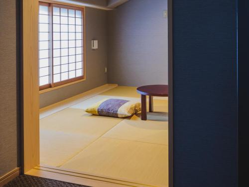 a small room with a bed and a window at Giappo Franca Kyoto in Kyoto
