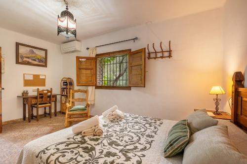 a bedroom with a bed and a table and a chair at La Terrera in Órgiva