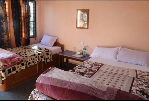 索拉哈的住宿－Nikunj Safari Guest House Sauraha，酒店客房设有两张床和一张桌子。