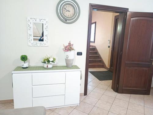 a hallway with a white cabinet with flowers on it at Casa Mandorle in Ugento