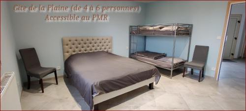 a bedroom with a bed and two chairs in it at Camping la Haie Penée **** in Saint-Quentin-en-Tourmont