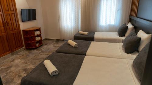 a hotel room with two beds and a tv at Rain Hotel in Kizkalesi