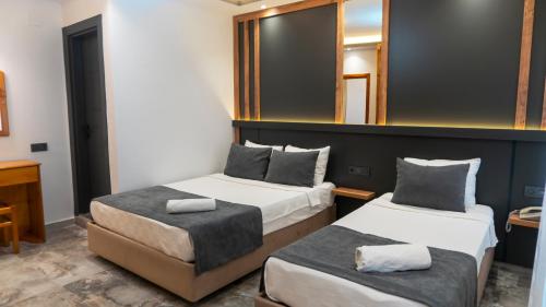 a hotel room with two beds and a mirror at Rain Hotel in Kizkalesi