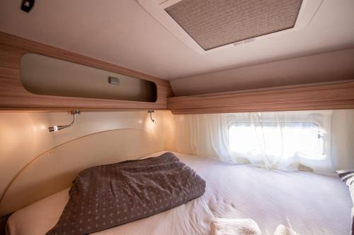 a small bed in the back of a rv at Autorulote Camperent in Ştefăneştii de Jos