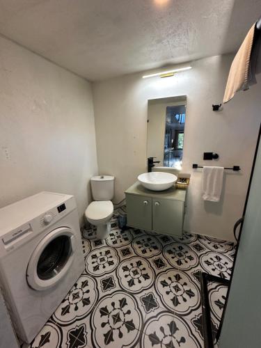 a bathroom with a sink and a washing machine at Gaia Tiny Houses Butik Hotel in Bodrum City