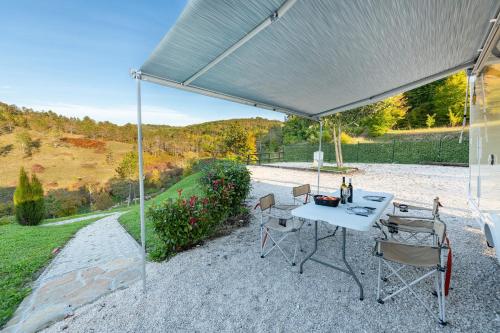 a patio with a table and chairs under a canopy at Autorulote Camperent in Ştefăneştii de Jos