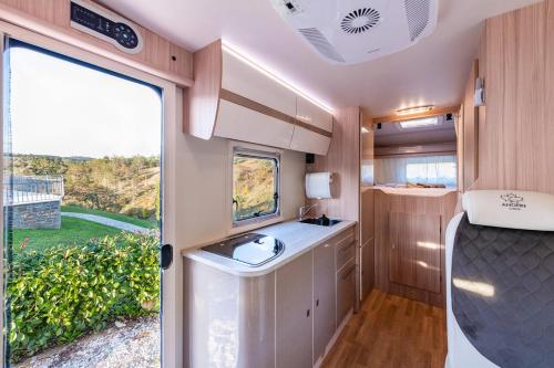 an rv bathroom with a sink and a window at Autorulote Camperent in Ştefăneştii de Jos