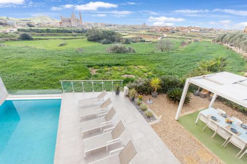 an aerial view of a patio with chairs and a pool at Twilight Gozitan Farmhouse With Pool - Happy Rentals in Għammar