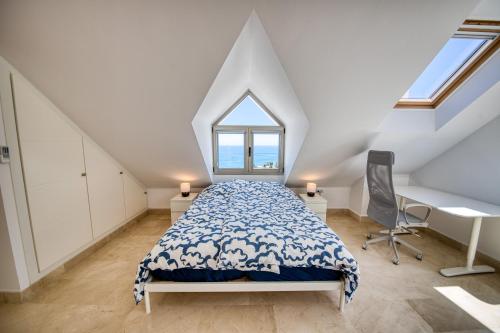 een slaapkamer met een bed, een bureau en een raam bij Penthouse Carabela Seaviews in Benalmádena