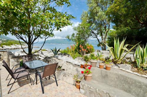 een patio met een tafel, stoelen en planten bij Holiday Home Brinic in Tivat