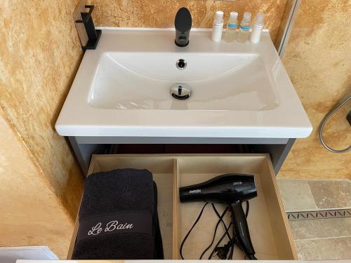 um lavatório branco numa casa de banho com uma caixa em Le perchoir nocturne em Payré-sur-Vendée