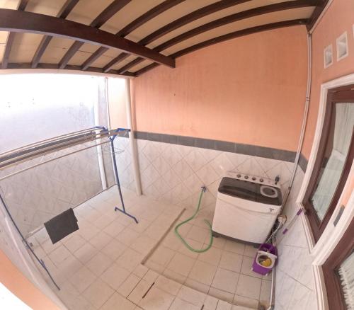 a bathroom with a washing machine in a room at Griya Sidoarum in Godean