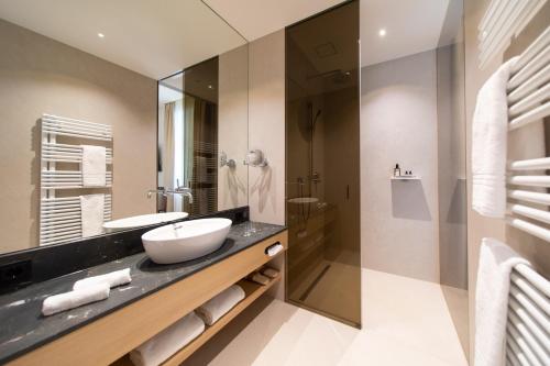 a bathroom with a sink and a shower at Apollo AchtQuartier Das Hotel am Mondsee in Mondsee