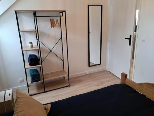 - une chambre avec un miroir et un lit dans l'établissement Appartement T2 proche centre/gare, à Lorient