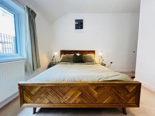 ein Schlafzimmer mit einem großen Holzbett in einem Zimmer in der Unterkunft Leah Suite by Koya Homes in Barry