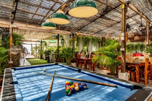 a pool table in a room with plants at Echo Beach Hostel in Ban Tai