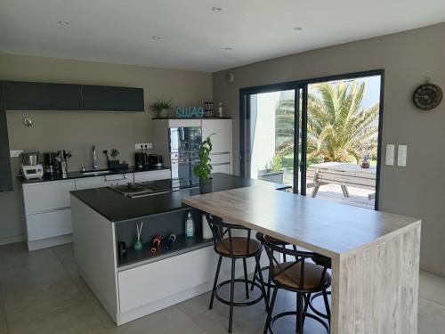 - une cuisine avec une table en bois et un comptoir dans l'établissement Casa Breizh & Fun, à Erdeven