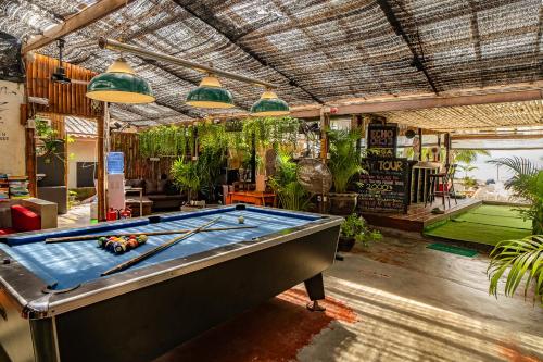 a pool table in a room with plants at Echo Beach Hostel in Ban Tai