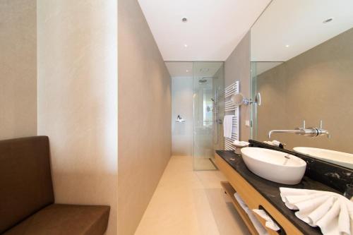 a bathroom with a sink and a mirror at Apollo AchtQuartier Das Hotel am Mondsee in Mondsee