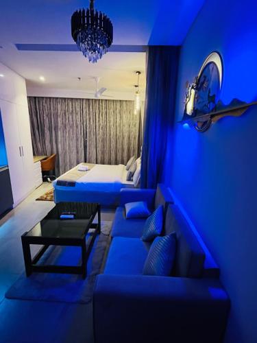 a blue living room with a couch and a bed at The Luxury Lodge in Noida